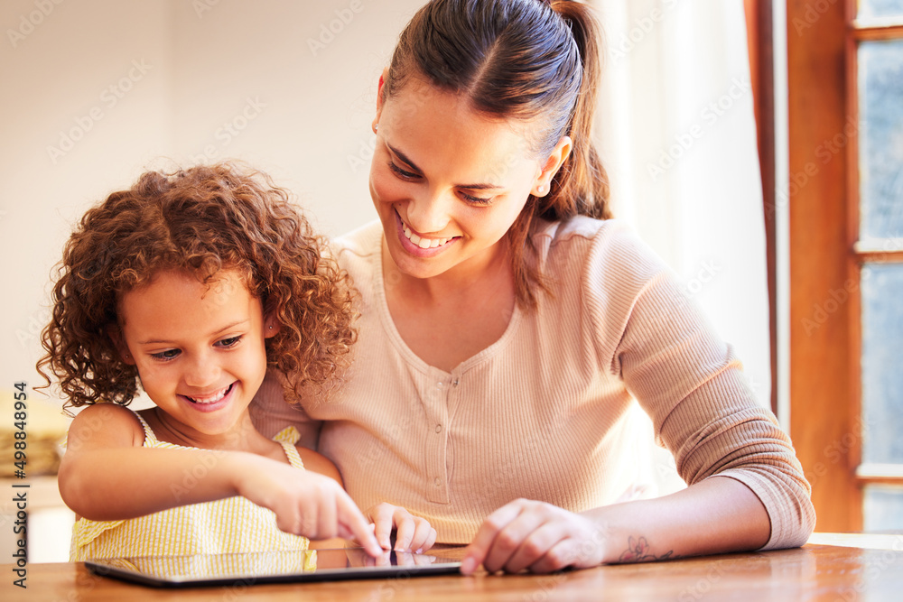 Mom can I play with the tablet. Shot of a young mother using a digital tablet together. Mom can I play with the tablet. Shot of a young mother using a digital tablet together.