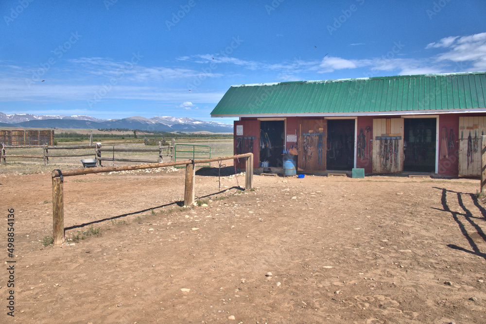 Wood horse barn in the Colorado Rocky Mountains in the background