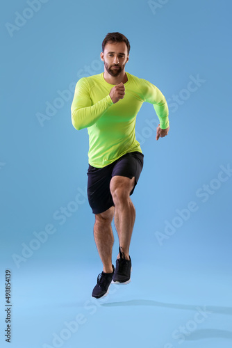 Sporty male runner on color...