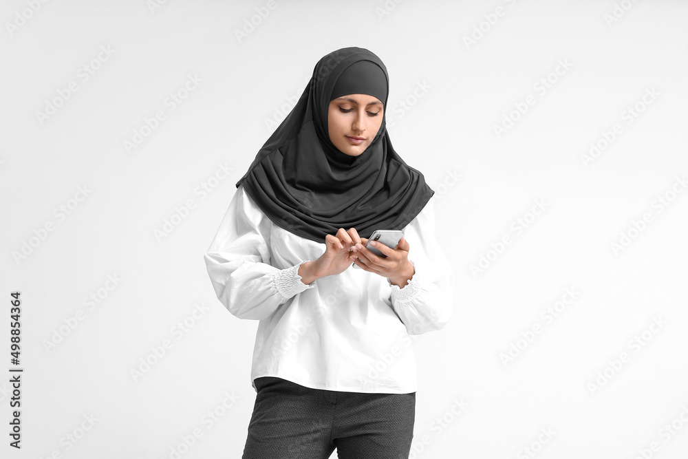 Muslim secretary with phone on light background Muslim secretary with phone on light background