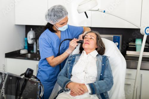 Fotografie Elderly female client receiving hardware mesotherapy to revitalize and tighten facial skin at cosmetology clinic