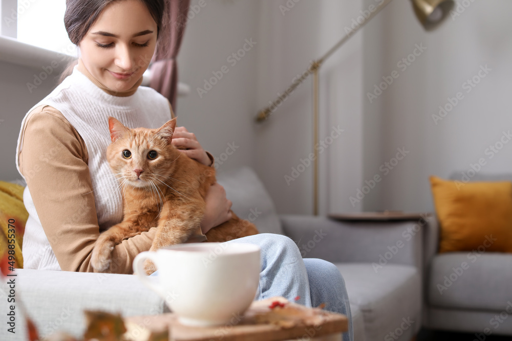 Woman with cute ginger cat at home on autumn day Woman with cute ginger cat at home on autumn day