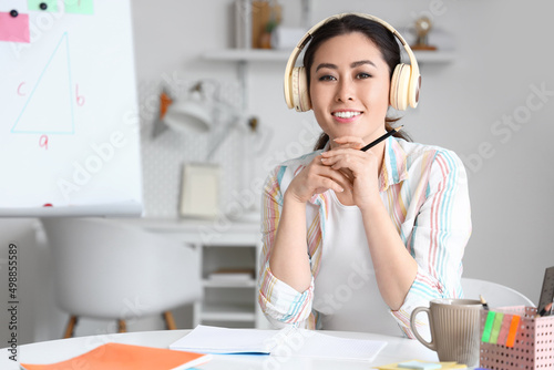 Young Asian tutor in headph...