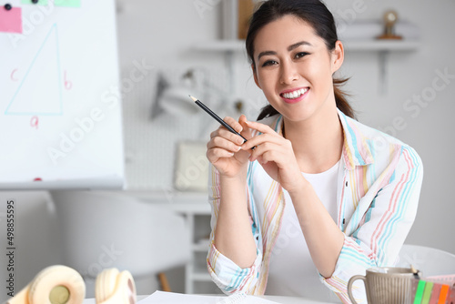 Young Asian tutor with penc...