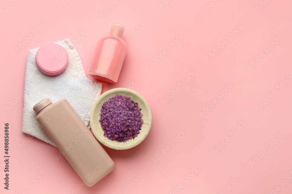 Cosmetic products, bowl of sea salt and clean towel on pink background Cosmetic products, bowl of sea salt and clean towel on pink background