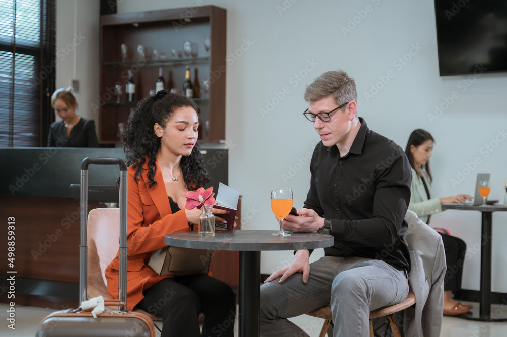Diverse business partners sitting in modern airport lounge with Diverse business partners sitting in modern airport lounge with