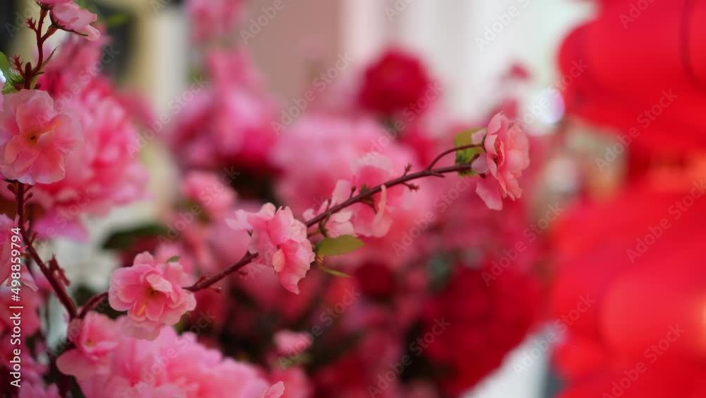 Pink artificial cherry blossom flower in festive bokeh background Pink artificial cherry blossom flower in festive bokeh background