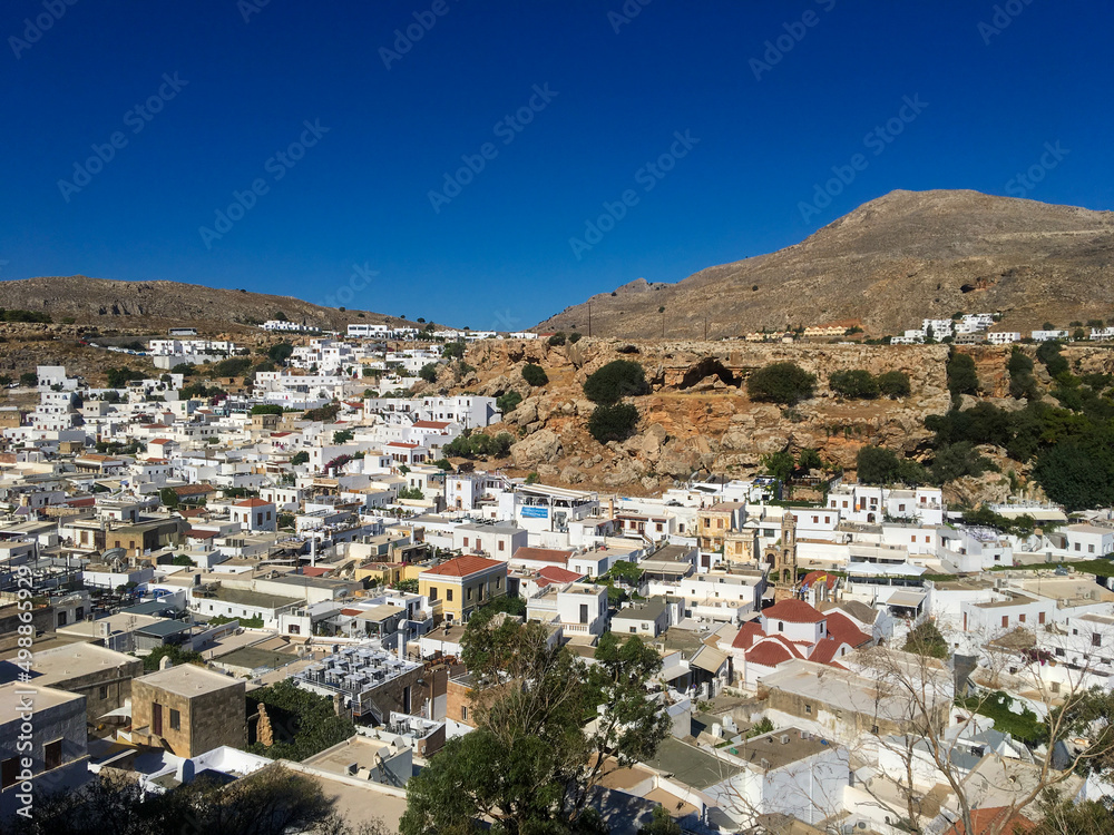 Rhodes, Greece - July 20, 2018: Beautiful view of the snow-white houses of the Greek city of Lindos against the blue sky