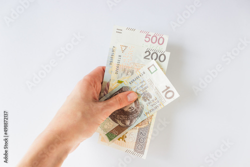 Woman's hand holds money, payment from United Nations to refugees from Ukraine in Warsaw - 710 PLN.