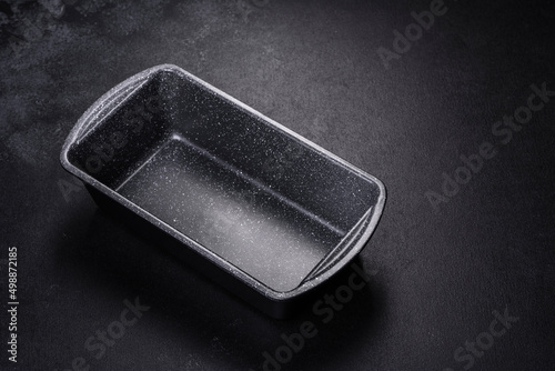 An empty ceramic grey baking dish on a dark concrete background