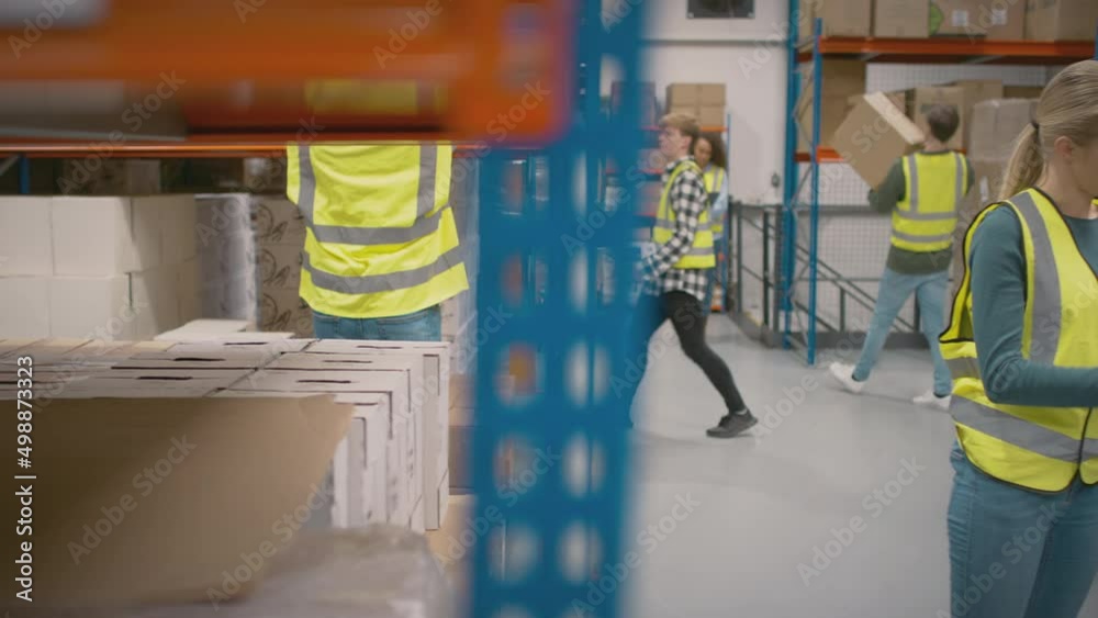Team leader with digital tablet in busy distribution warehouse training female intern- shot in slow motion Team leader with digital tablet in busy distribution warehouse training female intern- shot in slow motion