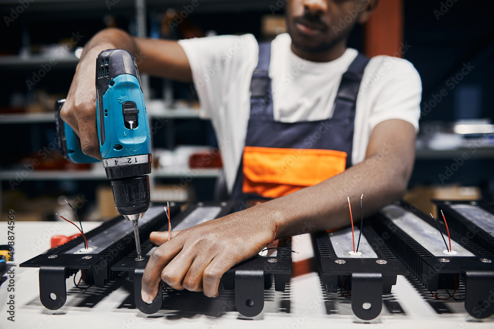 Factory worker using electric screwdriver Factory worker using electric screwdriver