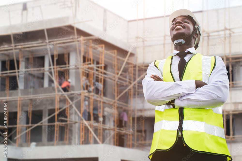 African architects engineer man in protective clothing and helmet working near the construction building site African architects engineer man in protective clothing and helmet working near the construction building site