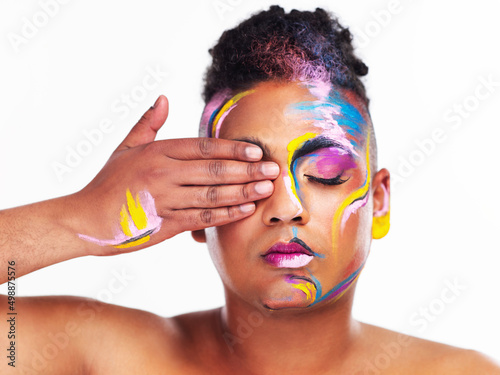 How you identify is your decision and no one elses. Cropped shot of a gender fluid young man wearing face paint against a white background. photo