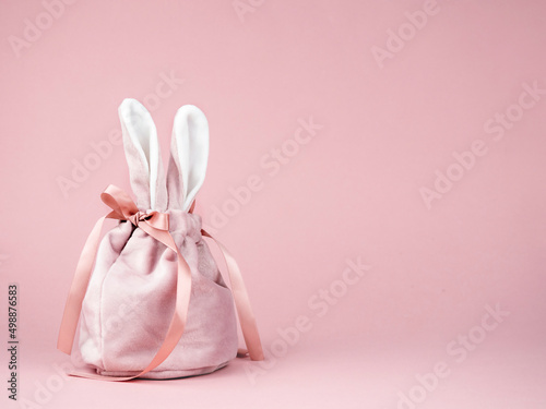 Pink baggie with bunny ears on a pink background. The concept of Easter, a gift