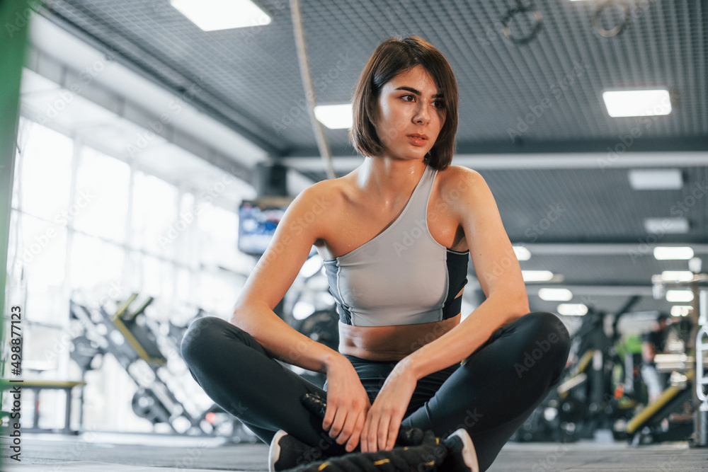 At daytime. Woman in sportive clothes with slim body type is in the gym At daytime. Woman in sportive clothes with slim body type is in the gym
