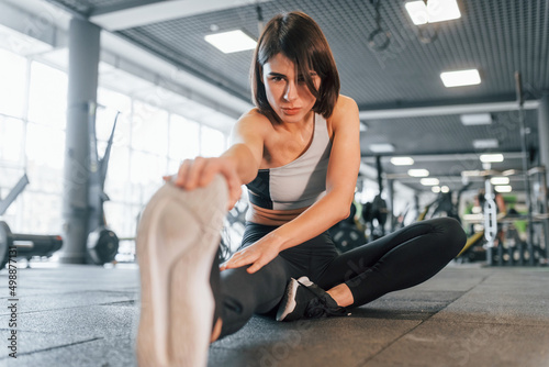 Woman in sportive clothes with slim body type is in the gym