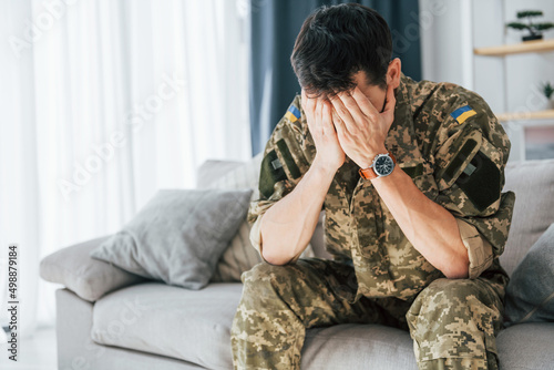 Having flashbacks. Post traumatic stress disorder. Soldier in uniform sitting indoors