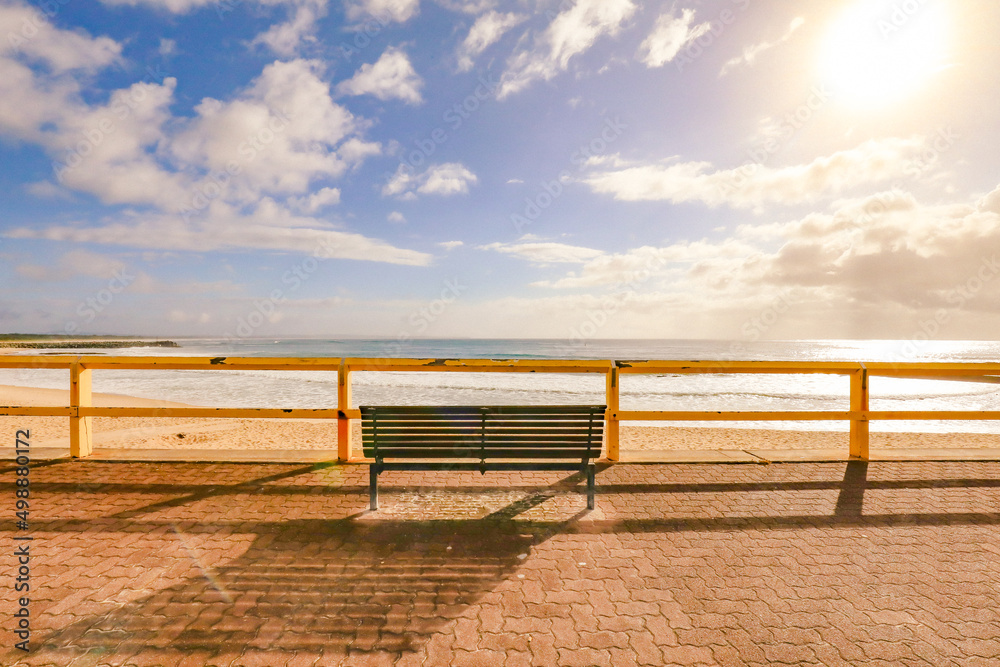 Fototapeta premium Empty park bench seat with beautiful beach view early in the morning at Forster Beach, NSW Australia