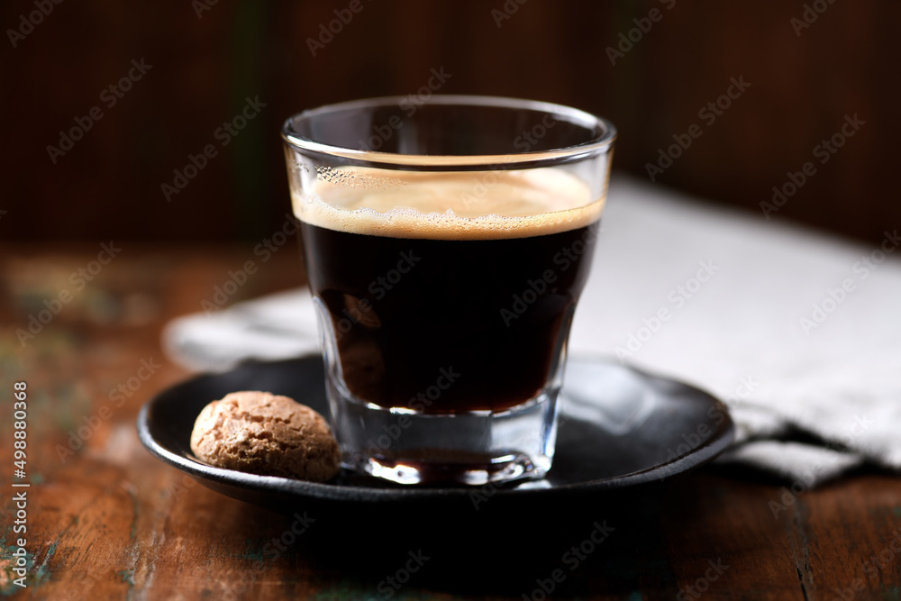 Coffee in glass cup on dark wooden background. Close up. Coffee in glass cup on dark wooden background. Close up.