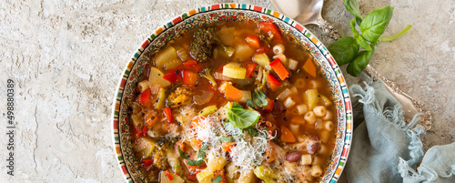 plate of minestrone soup on dark table photo