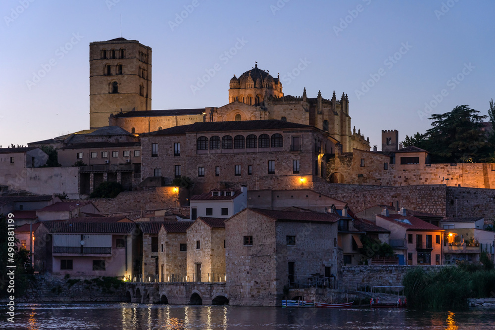 Zamora Romanesque cathedral and bell towers since Duero riverbank illuminated at night. Spain