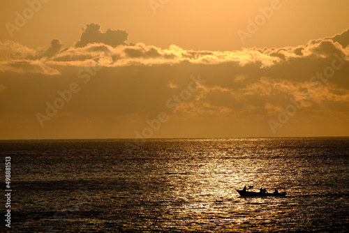 朝日に反射して輝く海面と雲