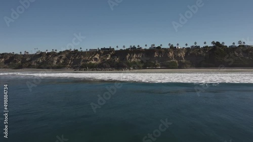 A beautiful aerial drone shot, drone flying towards the coast revealing a neighborhood with mountains in the background, Carlsbad State Beach - California photo