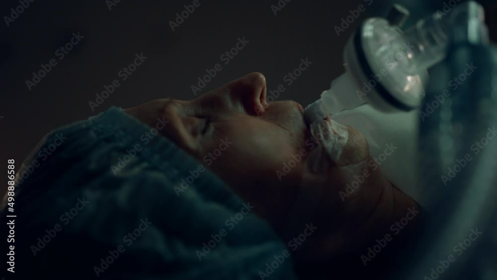 Patient surgical oxygen tube lying in dark sterile operating room portrait.