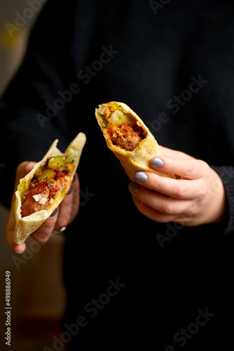 A girl is holding a kebab shawarma. Selective focus