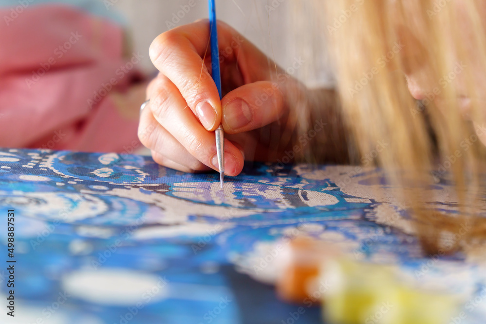 Close Up of woman Artist Hand, Holding Paint Brush and Drawing Oil Painting. Selective focus Close Up of woman Artist Hand, Holding Paint Brush and Drawing Oil Painting. Selective focus