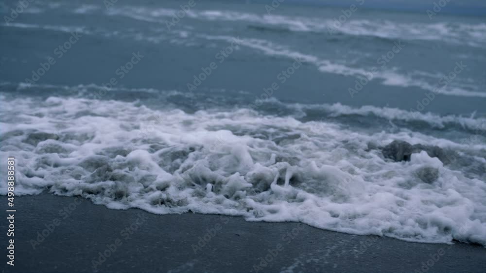 Ocean waves storming beach in dark blue background. Dangerous nature concept. Ocean waves storming beach in dark blue background. Dangerous nature concept.