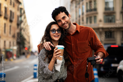 Traveling couple taking photos with camera. Loving couple walking through the city.