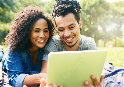 Making couple connections with some connectivity. Cropped shot of a young beautiful couple spending the day in a public park.