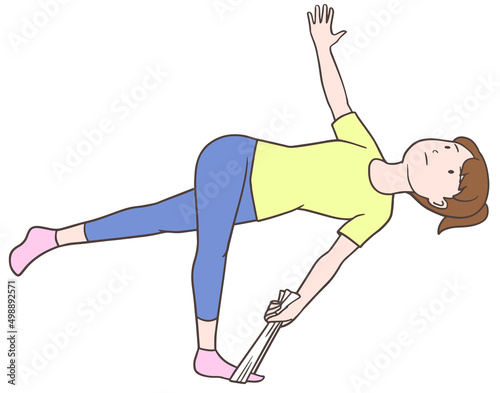 タオルで脚と股関節の外側をストレッチする女性