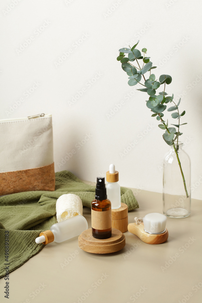 Skincare products, cosmetic bag and eucalyptus on beige table. Natural, organic cosmetics set.