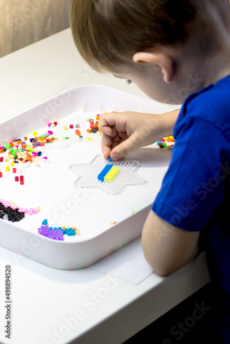 A child lays out the flag of Ukraine from a thermo mosaic. Patriot Boy