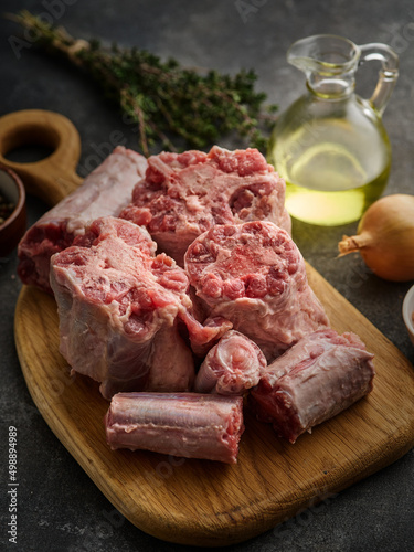 Fresh and raw oxtail cut on the cutting board on a grey background.