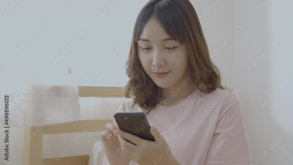 Holiday concept of 4k Resolution. Asian girls playing cell phones in the bedroom. Holiday concept of 4k Resolution. Asian girls playing cell phones in the bedroom.