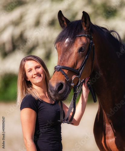 Horse and woman in portrait, woman schut smiling to the camera the horse looks attentively to the right..