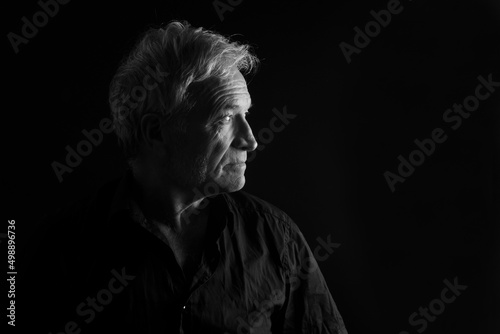side view of low key portrait of a senior man
