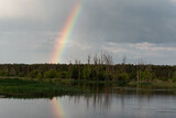 Rainbow reflecting in the river. Spring landscape by the water.