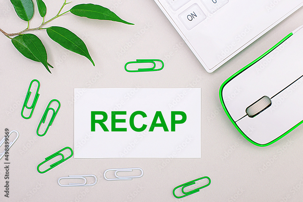 On a light background, a white calculator, a computer mouse, green
