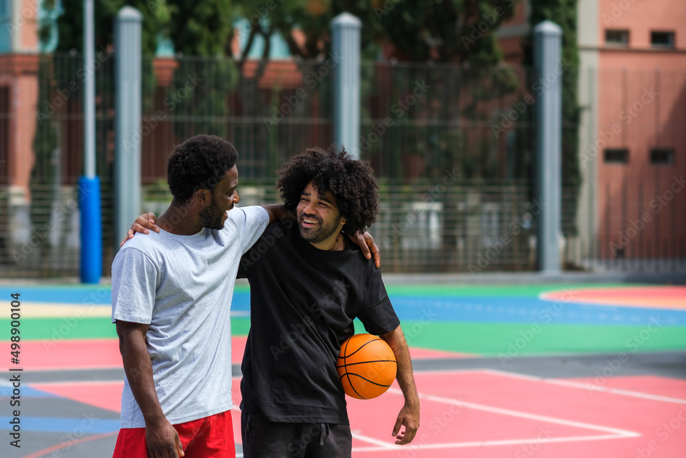 two friends hug happily while playing basketball