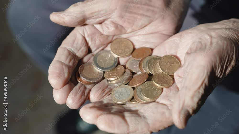 Problem of high rate poverty among the people in retirement, senior man holding stack of coins in his wrinkled hands, old man calculating miserable pension income and needs financial social assistance Problem of high rate poverty among the people in retirement, senior man holding stack of coins in his wrinkled hands, old man calculating miserable pension income and needs financial social assistance