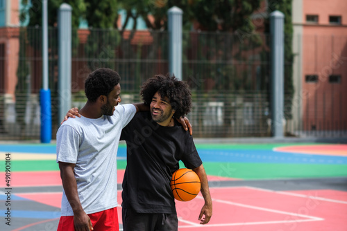 two friends hug happily while playing basketball