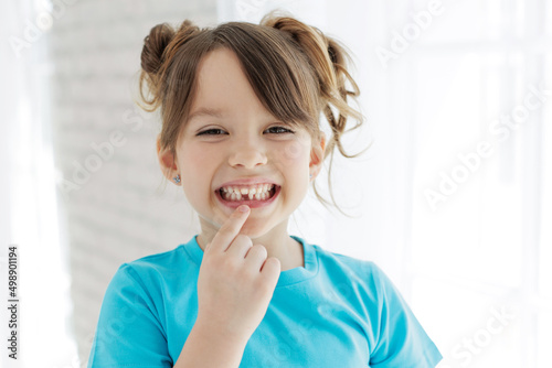 The kid lost a tooth. Baby without a tooth. Portrait of a little girl no tooth. High quality photo