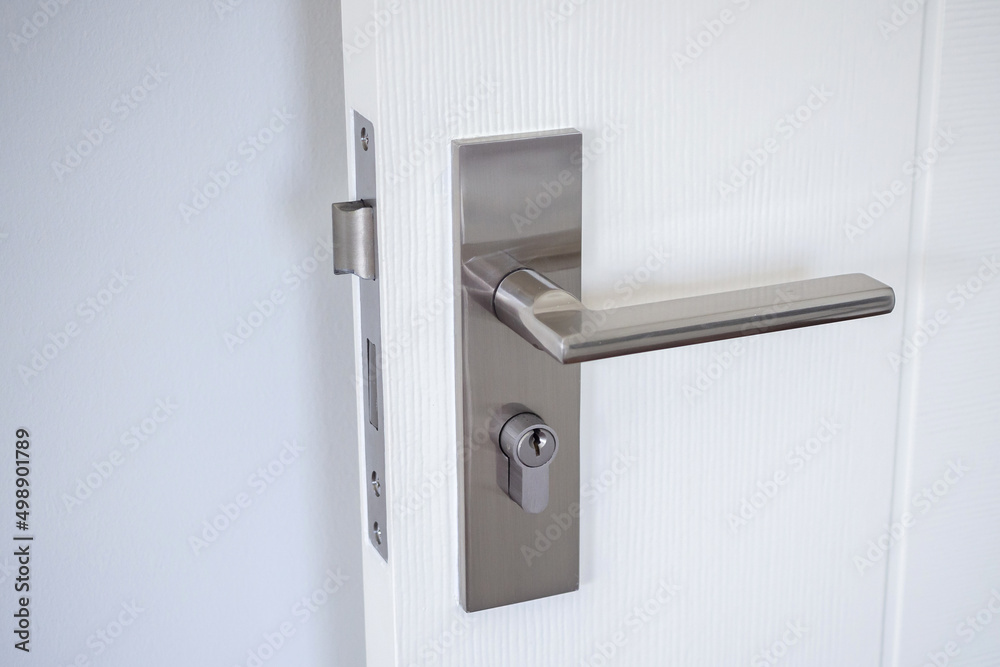 Modern door handle with on white door - obrazy, fototapety, plakaty 
