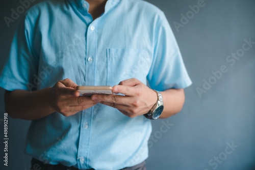 Business man using smartphone on blur background.