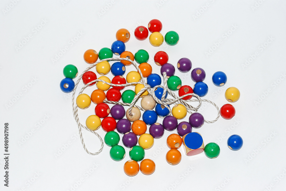 Wooden toy for baby, children isolated on white background. Wooden balls of different colors with a hole and a string. Wooden toy for baby, children isolated on white background. Wooden balls of different colors with a hole and a string.